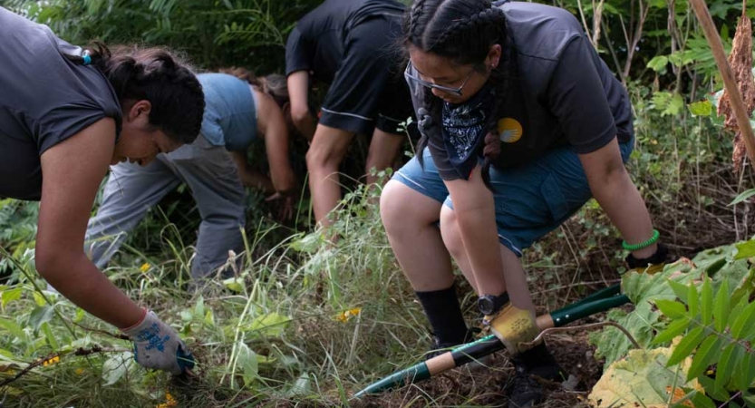 outward bound students use gardening tools during a service project